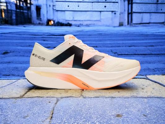 A New Balance SC Elite v4 shoe against a blue background.